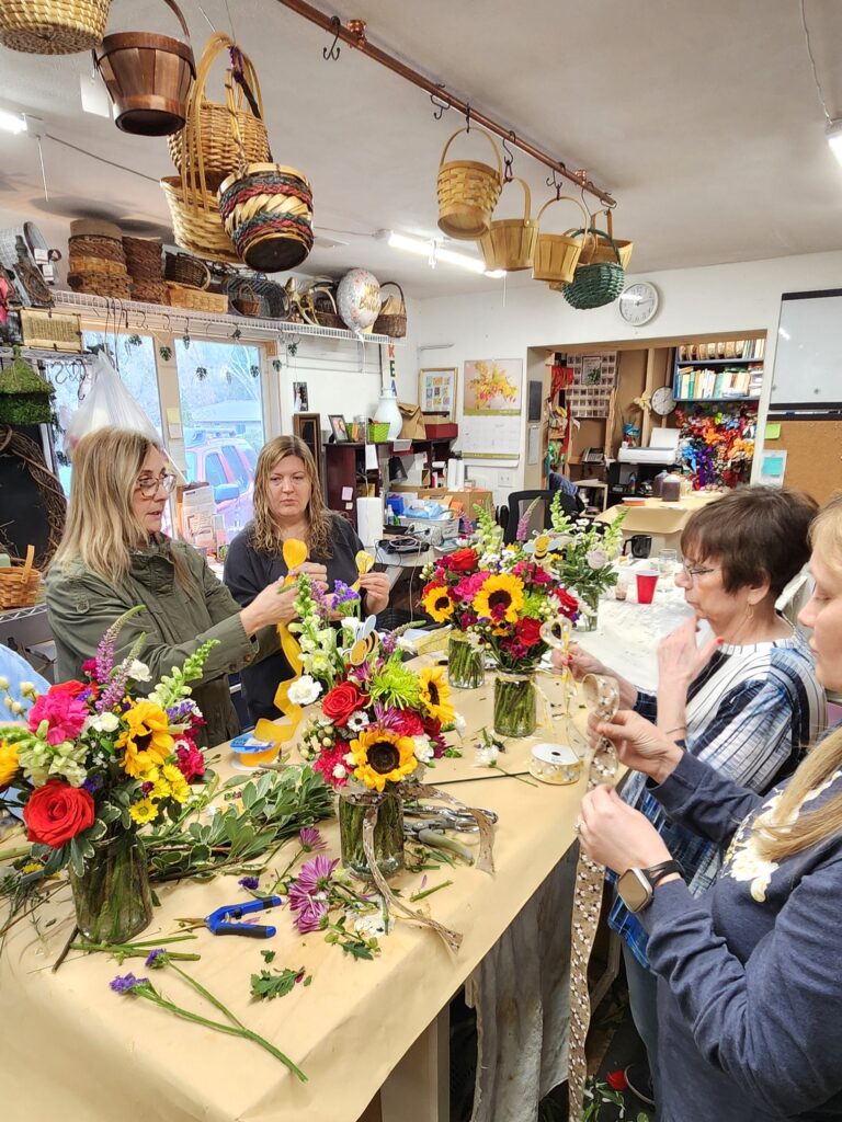 Participants creating floral arrangements together.