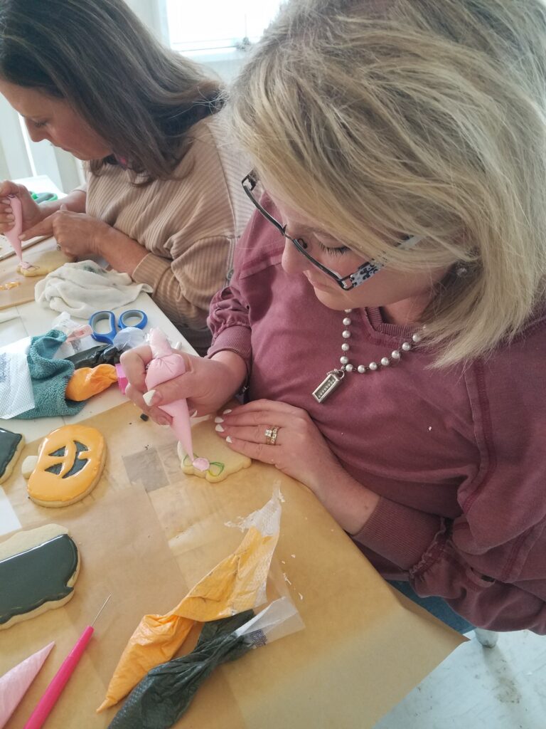 Women decorating cookies at workshop.