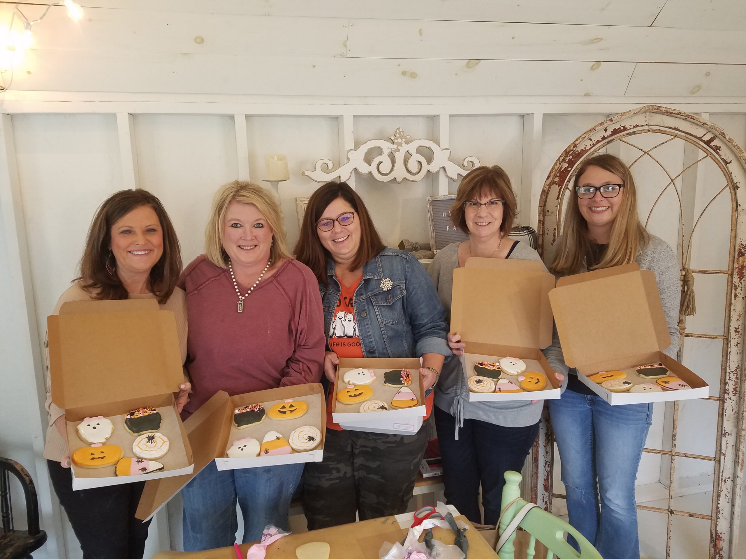 Group holding decorated cookie boxes.