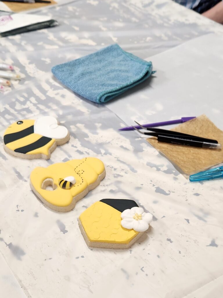Decorated bee-themed cookies on table
